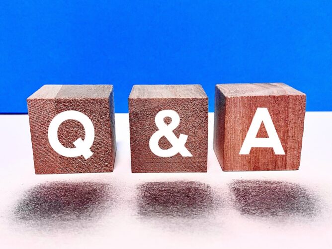 26841561_m | M Virtual(エムバーチャル) - Vライバーマネジメント事務所 Three wooden blocks spell out Q & A on a white surface with a bright blue background, illustrating a Q&A concept.