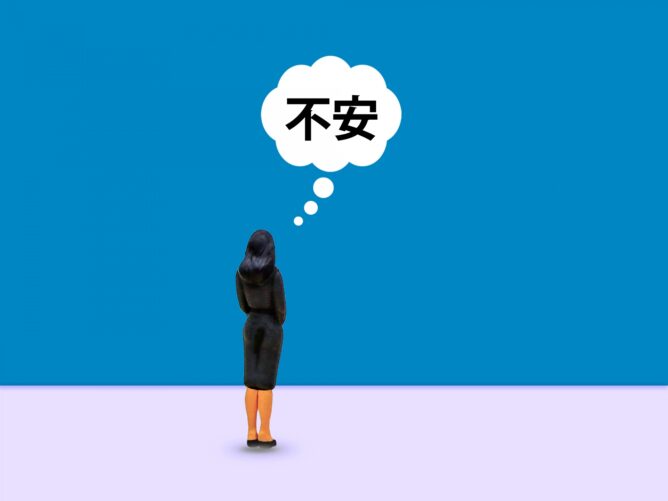 34355817_m | M Virtual(エムバーチャル) - Vライバーマネジメント事務所 Person facing away, standing on a pale floor, with a thought bubble showing '不安' (unease) against a blue background.