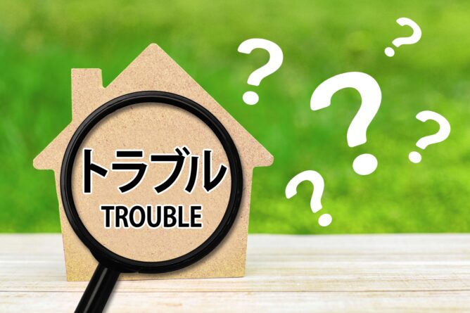 34493225_m | M Virtual(エムバーチャル) - Vライバーマネジメント事務所 Magnifying glass over a cardboard house with the words トラブル (Trouble) and question marks around it, suggesting home-related problems or troubleshooting.