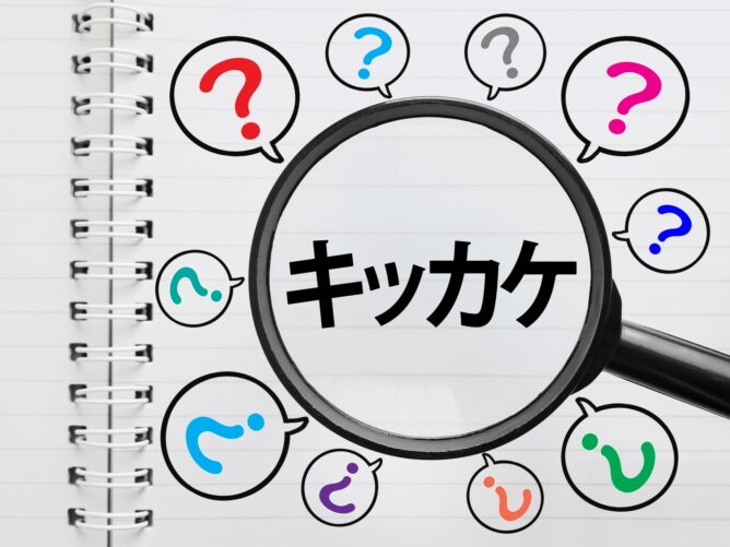 32356115_m | M Virtual(エムバーチャル) - Vライバーマネジメント事務所 Magnifying glass over a notebook page with the Japanese word キッチン and colorful question-mark speech bubbles around it