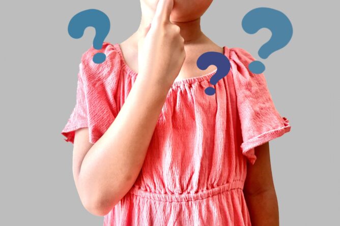33092315_m | M Virtual(エムバーチャル) - Vライバーマネジメント事務所 Child in a pink dress touches their chin with a puzzled expression and floating question marks around them, indicating confusion or uncertainty.