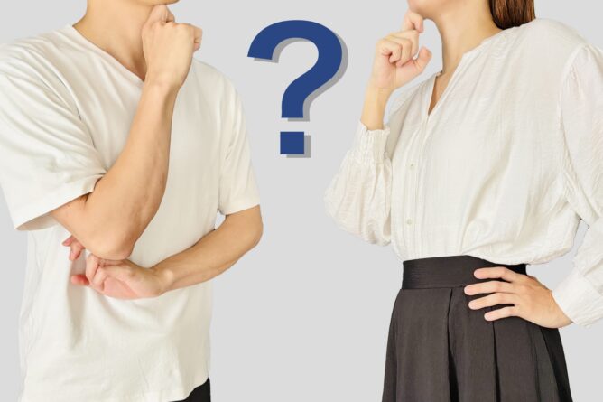 33322112_m 1 | M Virtual(エムバーチャル) - Vライバーマネジメント事務所 Two people in white shirts on opposite sides, hands near their faces, with a large blue question mark between them, symbolizing a question or uncertainty.
